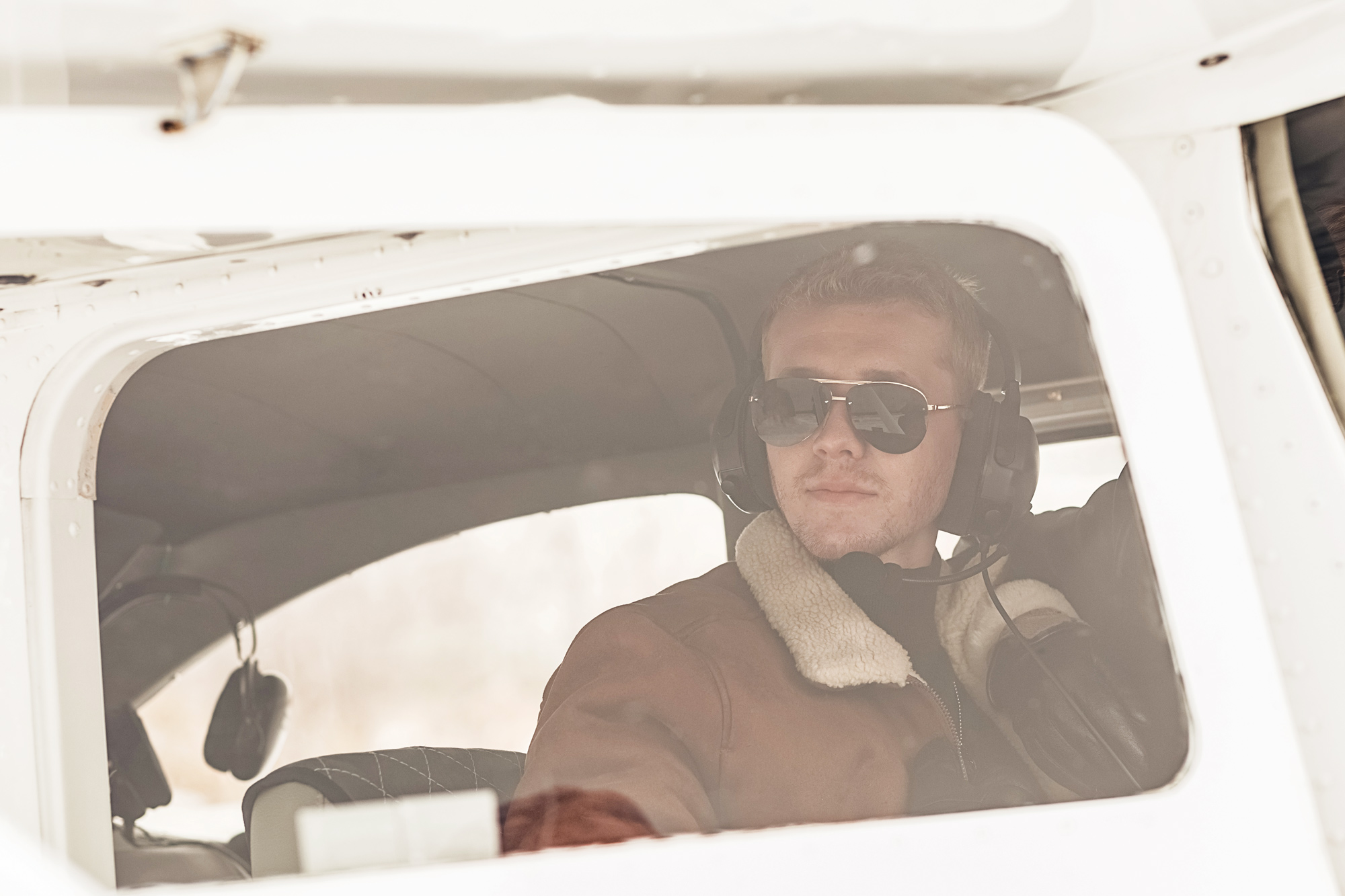 Warmly dressed pilot in an airplane cockpit.